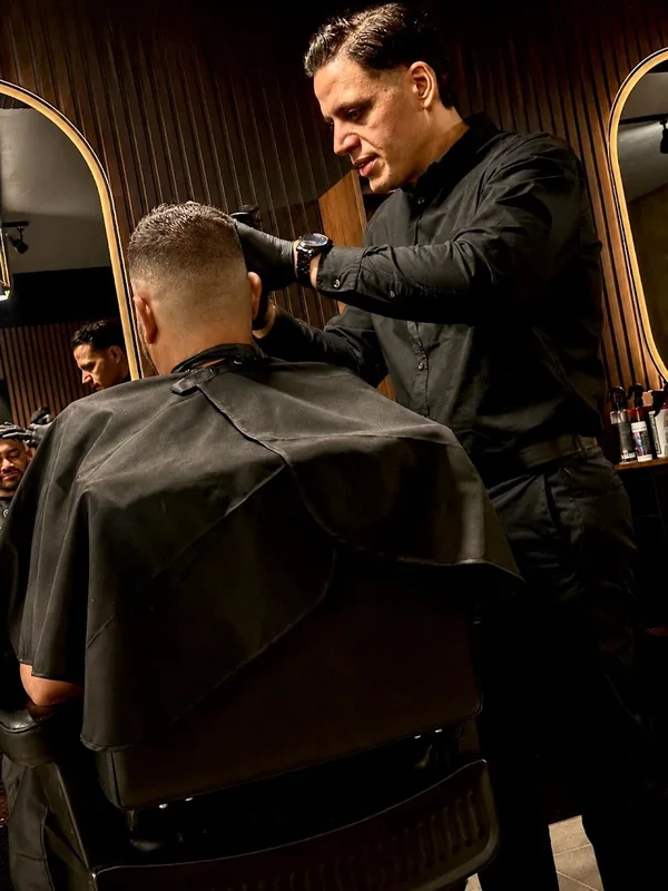 Portada: barbero trabajando frente al espejo